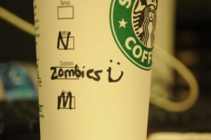 A paper Starbucks cup with Zombies written on it.