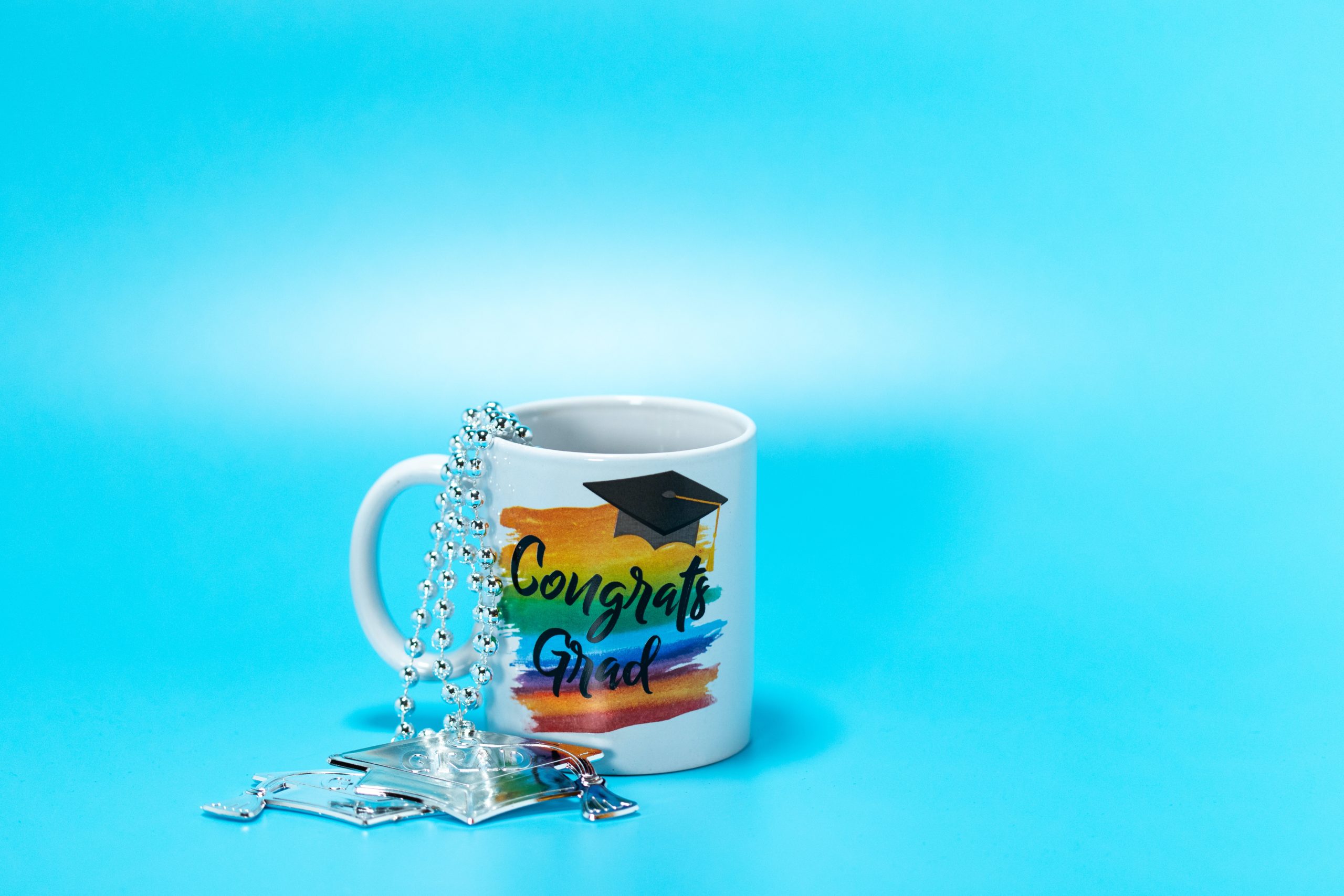 A photo of a coffee mug with the words "Congrats Grad" written on the side.